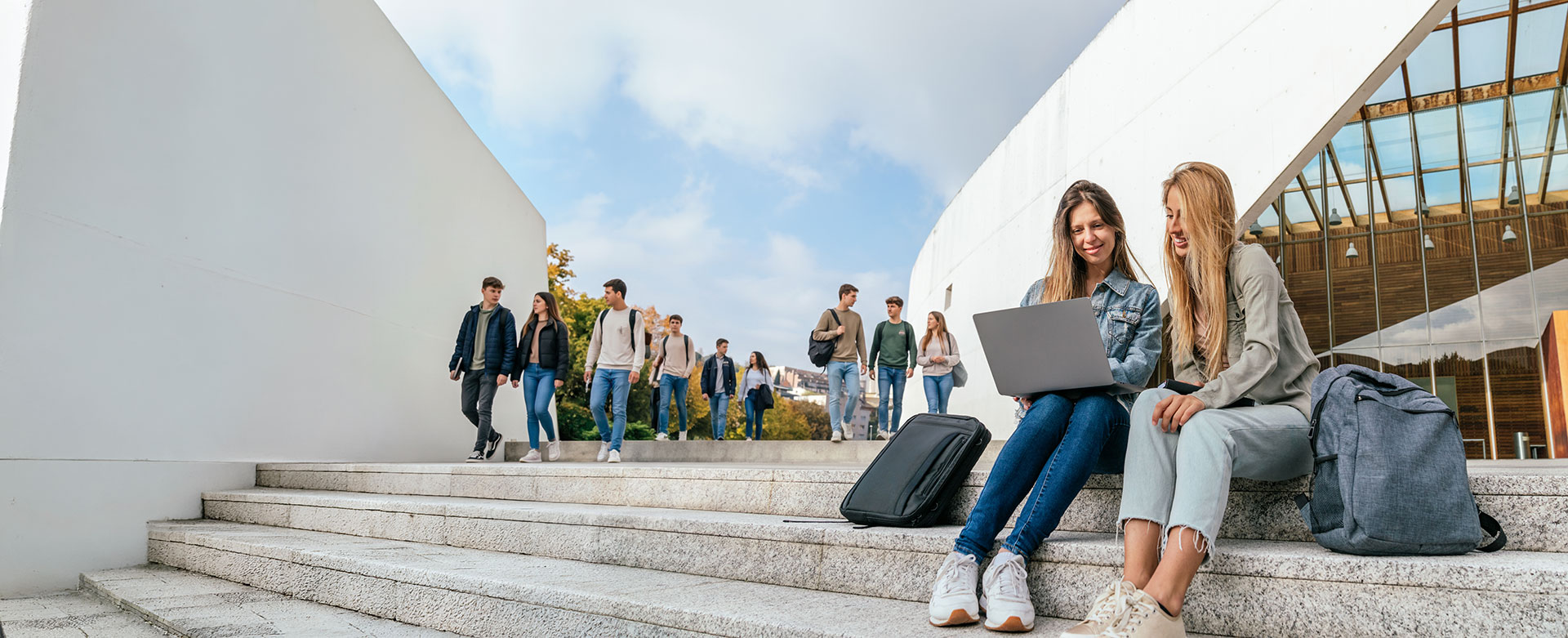 Zwei Schülerinnen vor einem Schulgebäude