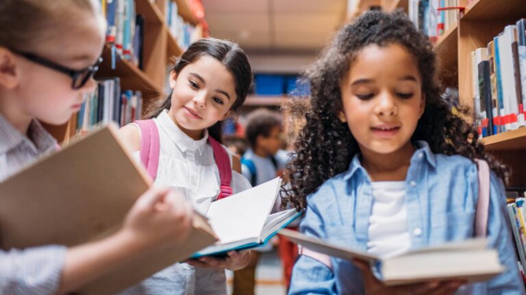 Kinder lesen gemeinsam Bücher in der Schulbibliothek
